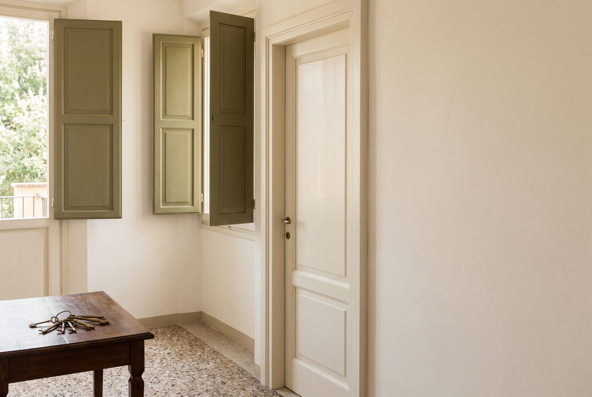 Mazzo di chiavi su una consolle di legno accanto alla porta d'ingresso di un appartamento vuoto