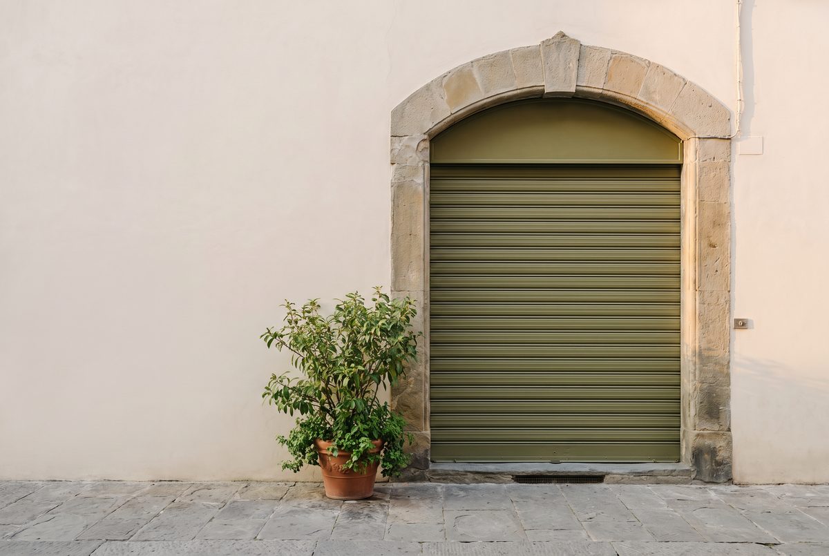 Saracinesca abbassata di un piccolo negozio in una via lastricata italiana